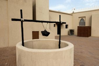 A traditional desert house showcasing an ancient well in an outdoor courtyard.