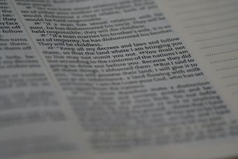 Close-up view of Holy Bible text with soft focus creating a spiritual ambiance.