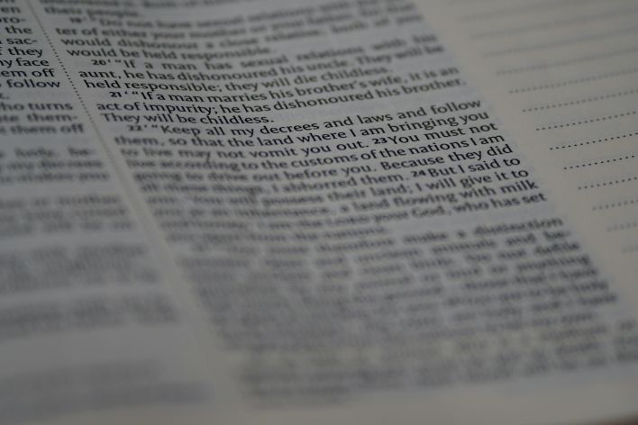 Close-up view of Holy Bible text with soft focus creating a spiritual ambiance.