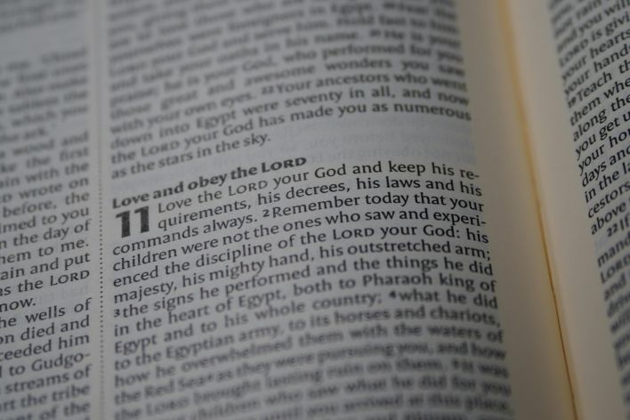 A detailed close-up of a Bible page focusing on a passage about love and obedience to God.