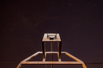 A low angle shot of a basketball hoop against a starry night sky.