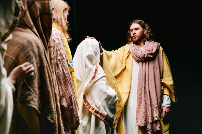 A dramatic biblical reenactment featuring Jesus among followers, conveying spirituality and faith.