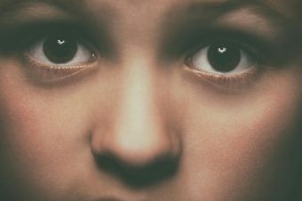 Detailed close-up of a child's face focusing on expressive brown eyes, conveying emotion.