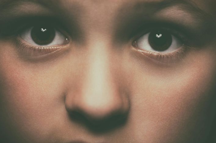 Detailed close-up of a child's face focusing on expressive brown eyes, conveying emotion.